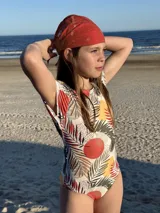 Traje de baño enterizo de niña, con estampado de hojas y círculos, manga corta y moño en la espalda.