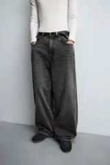 Pantalón de jeans de algodón, corte baggy fit, tiro medio, con efecto lavado en tonos grises y verdes. Presenta cinco bolsillos y cierre frontal con cremallera y botón.