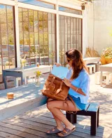 Mochila de cuero marrón con cierre superior y múltiples bolsillos externos. Se puede convertir en bolso de mano o bandolera gracias a sus correas ajustables y extraíbles.