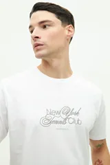 Remera blanca de manga corta con estampado frontal que dice "New York Tennis Club".
