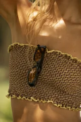 Top de bikini strapless color fucsia con textura arrugada y volados celestes en los bordes.