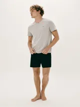 Pijama de dos piezas compuesto por remera manga corta gris con cuello en V y bordado de logo en el pecho, y short negro.