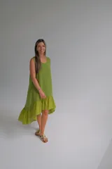 Vestido verde pistacho de lino italiano, corte suelto, sin mangas, con escote redondo y ruedo asimétrico con volados.