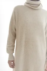 Vestido sweater largo de punto color verde oliva, con cuello alto y mangas largas.