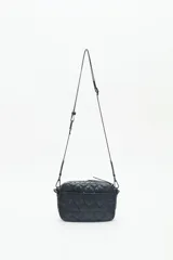 Bandolera negra de nylon matelassé con correa regulable, avíos metálicos, llavero de corazón y dijes desmontables.