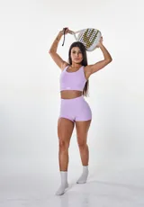 Conjunto deportivo lila compuesto por un top con breteles finos y un short de calce ajustado.