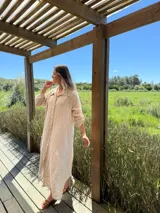 Vestido camisero amplio y largo de lino color azul, con botones de nácar, cuello camisero y bolsillos laterales.