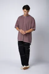 Remera negra oversize con mangas cortas y costuras a la vista en color blanco.