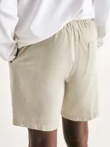 Bermuda verde de tela texturizada con cintura elastizada y cordón de ajuste.