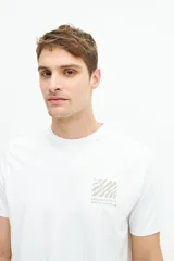 Remera blanca de algodón con estampado de recuadros con motivos botánicos en tonos grises y beige en la espalda.