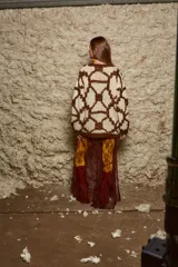 Sweater de lana tejido a mano con diseño geométrico en color crema y marrón.