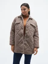 Campera negra de pana con diseño acolchado en forma de rombos, cuello camisero, cierre con botones a presión, bolsillos de parche con solapa en el pecho y bolsillos laterales.