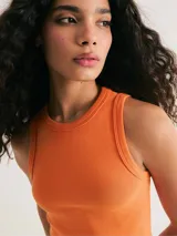 Top corto marrón de tela acanalada, con cuello redondo y sisas anchas.