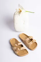 Sandalias de cuero color beige con dos tiras anchas y hebillas doradas ajustables.