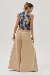 Pantalón jean de pierna ancha color beige, con cintura elastizada y bolsillos traseros cuadrados.
