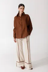 Camisa blanca de lino con botones de madera, corte recto y mangas largas.