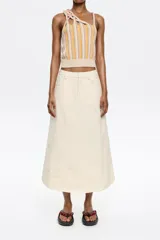 Falda midi color crudo con bordados florales y corte evasé.