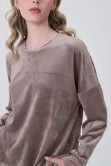 Buzo de terciopelo color marrón, de corte holgado, cuello redondo y manga larga.