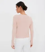 Cárdigan rosa de tejido de punto, con cuello redondo con borde ondulado, cierre frontal con botones y mangas largas con puños acanalados.