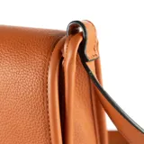 Bandolera color marrón de cuero sintético con textura graneada. Tiene correa regulable, acceso con solapa, herrajes plateados y un bolsillo interno con cierre.