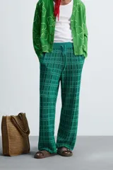 Pantalón relaxed fit de punto ligero tejido en hilatura con algodón, color verde con diseño a cuadros. Cintura elástica ajustable con cordón y bolsillos laterales.