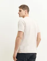 Remera color petróleo de manga corta con estampa de un edificio y texto en el frente.