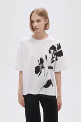 Remera blanca de corte holgado con estampado de flores negras.