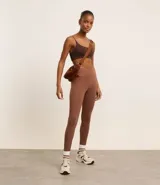 Calza deportiva color marrón, de tiro alto y largo hasta el tobillo.