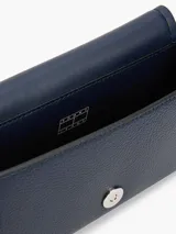 Bandolera Tommy Jeans azul marino con correa ajustable, cierre con solapa y logo de la marca en el frente.