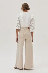 Blusa blanca de mangas 3/4 con bordado calado y cuello redondo con volados.