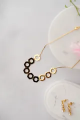 Collar moderno de acero quirúrgico con hexágonos en dorado y negro, con baño de oro de 18k.
