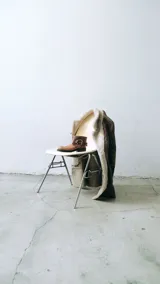 Botas cortas de cuero sintético color gris oscuro, con hebilla metálica plateada y cierre lateral.