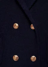 Chaqueta azul marino de punto medio con cuello de pico con solapa, cierre cruzado de doble botonadura con botones dorados efecto joya, diseño recto, solapas con muesca y dos bolsillos de parche frontales.