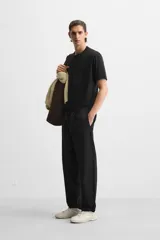 Pantalón de hombre color beige, corte carrot fit, con cintura elástica ajustable con cordón, bolsillos frontales y bolsillo trasero de plastrón.