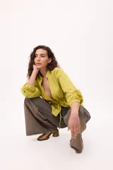 Chaqueta azul con cuello mao, mangas largas abullonadas y lazo en la cintura.