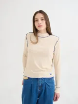 Polera negra de tela rib con cuello alto y mangas largas. Presenta pespuntes rojos en cuello, hombros y puños.