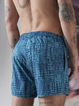 Short de baño color borgoña con estampado de hojas en tono sobre tono, cintura elástica con cordón ajustable y logo de la marca en la pierna.