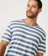 Conjunto de pijama corto para hombre, compuesto por remera de manga corta con cuello redondo y short con cintura elástica. Diseño a rayas horizontales en tonos azul y blanco.