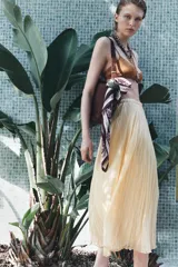 Falda midi color amarillo pálido con cintura elástica y tejido con efecto arrugado.
