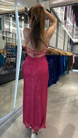 Vestido largo de fiesta fucsia con lentejuelas, escote halter, espalda descubierta y tajo lateral.