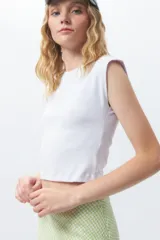 Crop top de algodón blanco, sin mangas y diseño ajustado.
