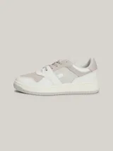 Zapatillas urbanas Tommy Jeans de corte bajo, con exterior de piel en tonos blanco, gris y beige. Presentan suela gruesa de goma, cordones y logo de la marca en el lateral y el talón.