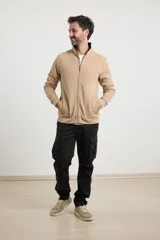 Cardigan de corte clásico con cierre frontal y manga larga, presenta detalles de tejido plano y bolsillos laterales.