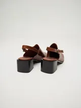 Zuecos clásicos color beige, hechos 100% en cuero vacuno wax y charol, con taco de madera de 5cm de altura y correa trasera ajustable.