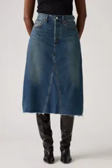 Falda midi de jean azul con corte en A, tiro alto, cierre frontal con botones y ruedo desflecado.