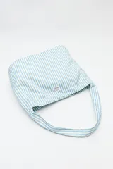 Bolso de hombro con estampado de rayas verticales celestes y blancas.