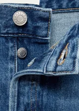 Pantalón de jean azul de corte wide leg, tiro medio, con cierre de cremallera y botón, bajo con dobladillo y cinco bolsillos.