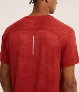 Remera deportiva color ladrillo con estampa cuadriculada y textura. Confeccionada con tecnología dry, cuello redondo y manga corta. Corte regular.