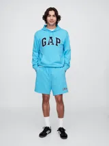 Short deportivo de algodón color celeste claro, con cintura elástica y cordón de ajuste. Presenta el logo "GAP" bordado en blanco y azul marino en la pierna izquierda.