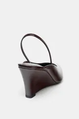 Zapato destalonado color marrón con tacón de cuña y punta fina.